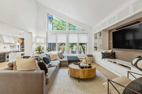Modern living room with large windows, cozy sofa, and a stylish coffee table.